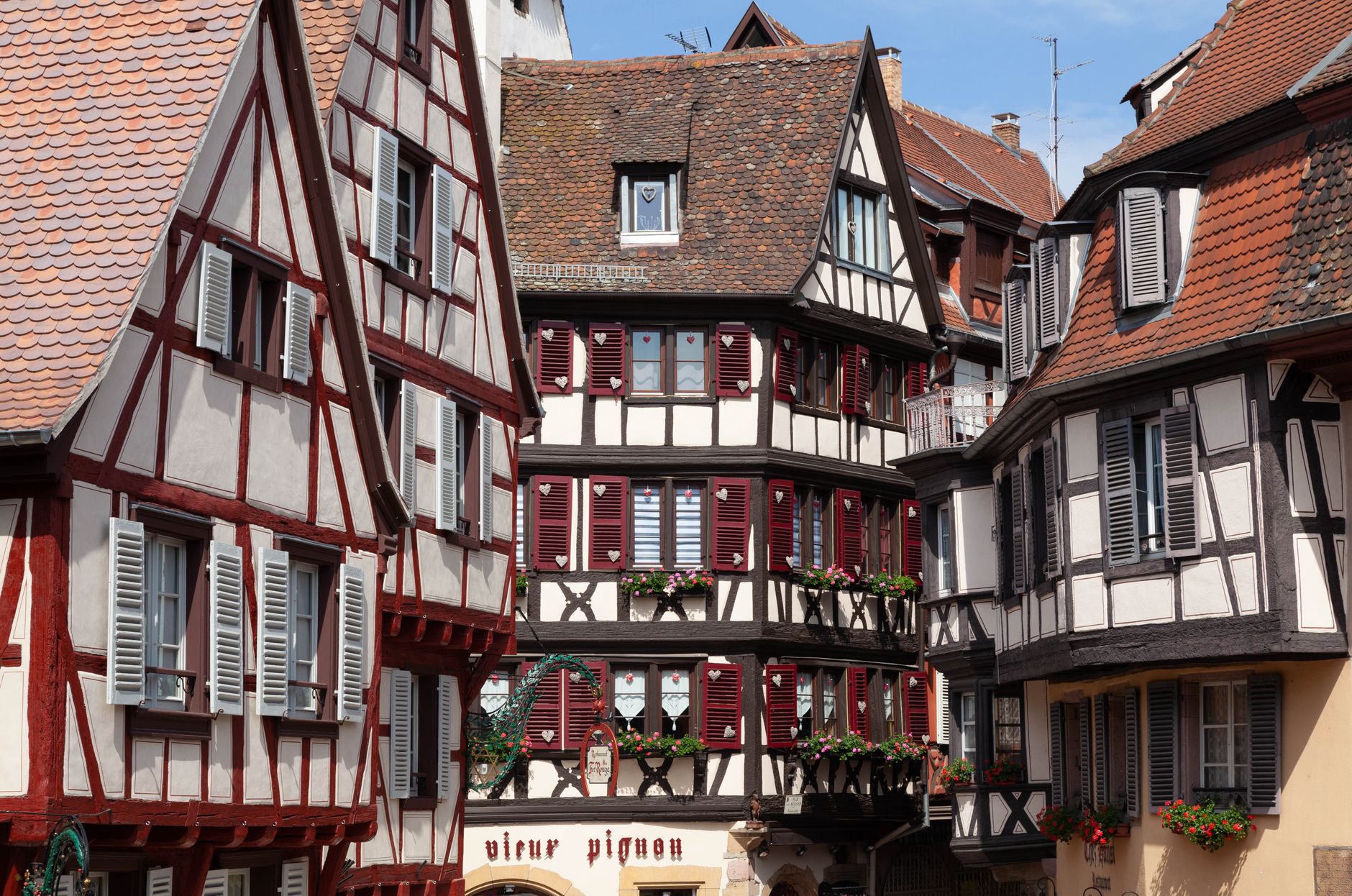 maisons à colombages aux volets rouges dans une rue de vieille ville alsacienne
