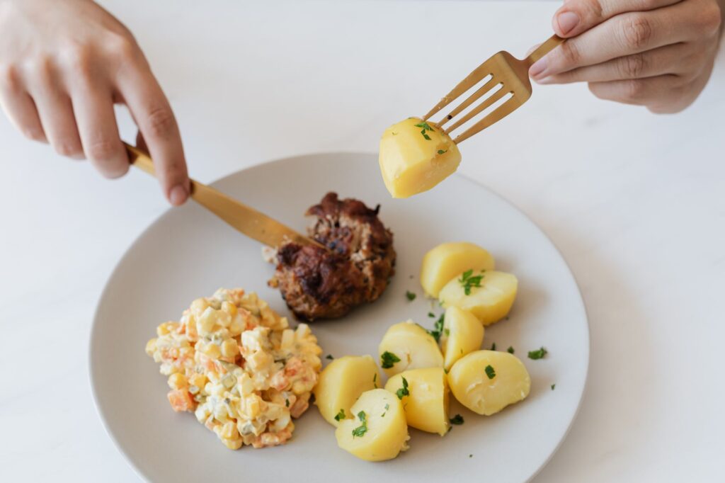 assiette de pommes de terre vapeur persillées avec une portion de salade