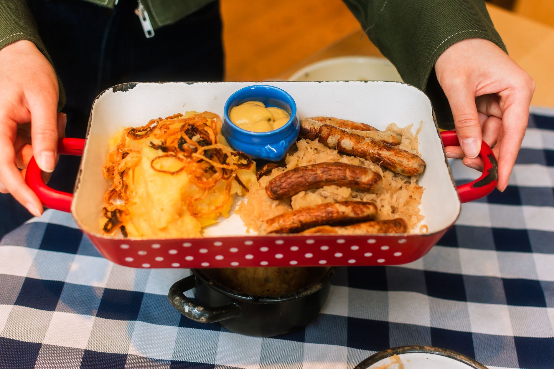 plat de choucroute garnie avec saucisses et purée sur une nappe à carreaux